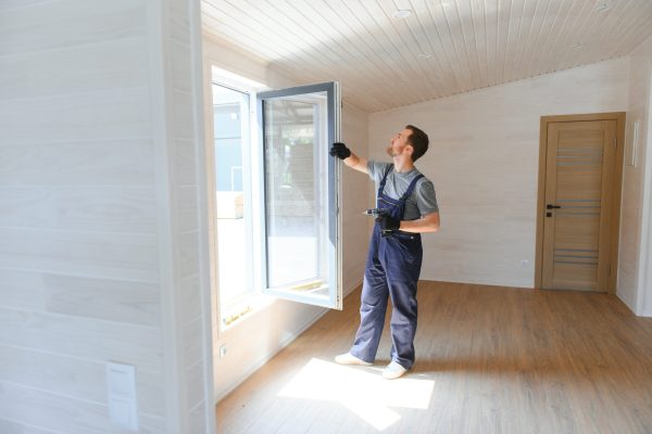 The worker installing and checking window in the house